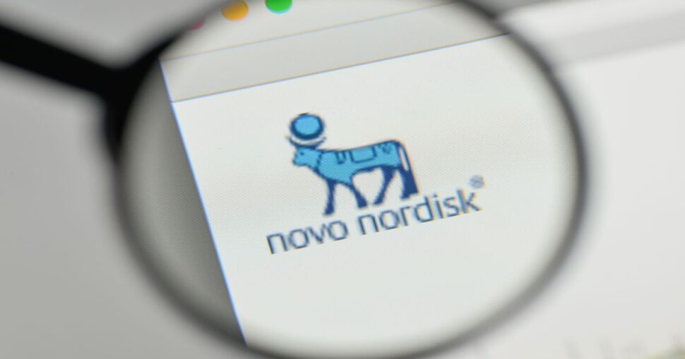Lupe vergrößert das blaue Logo eines stilisierten Stieres mit dem Text "novo nordisk".